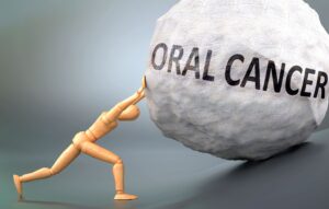 Drawing model figure pushing a large boulder labeled "Oral Cancer"